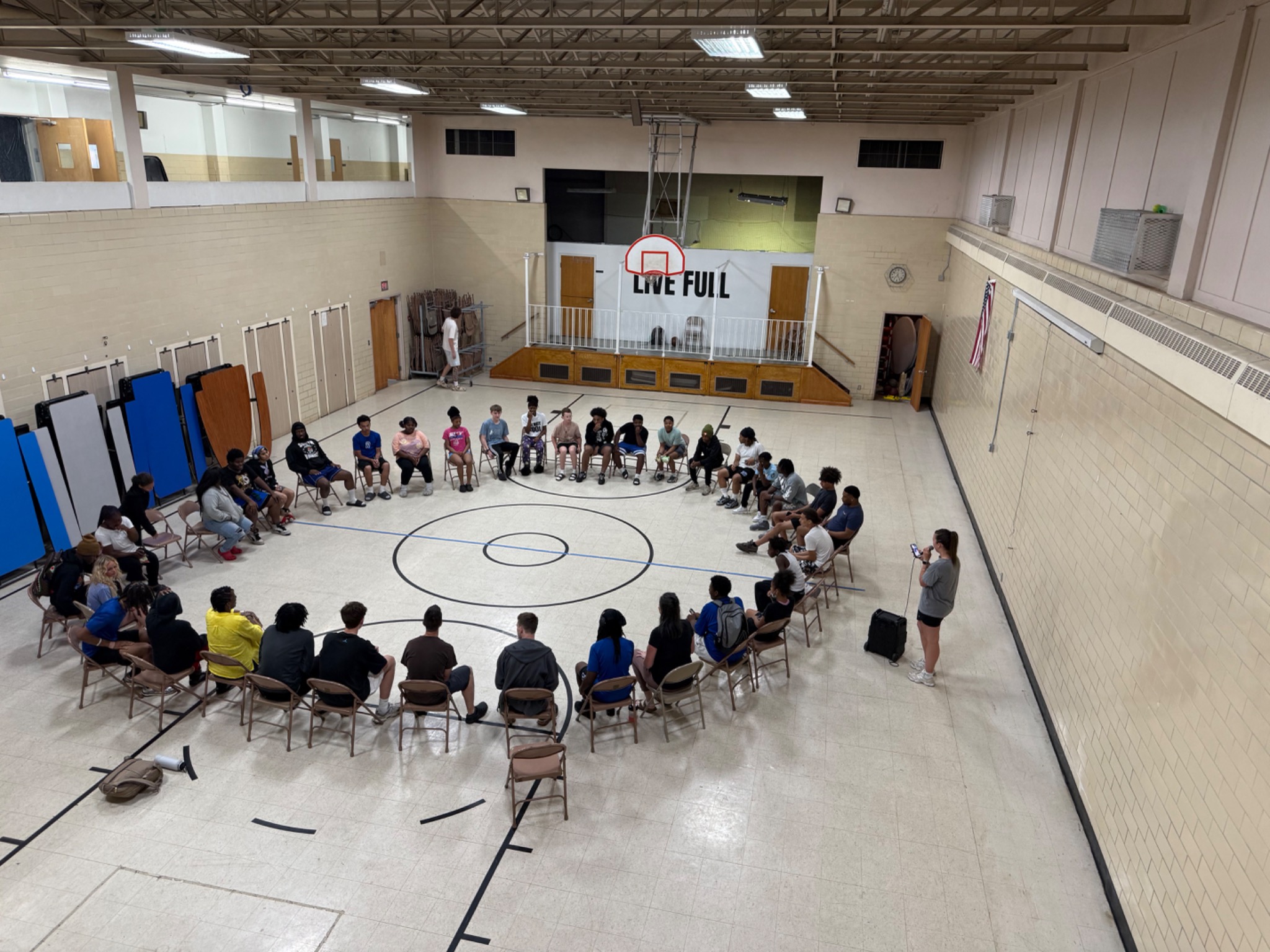 LIVE FULL teens seated in a large circle in the church gym